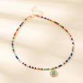 Collier bohème en perles colorées avec pendentif lettre E doré et turquoise - Lettre E