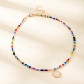 Collier de perles colorées avec pendentif doré rond, lettre P et texture martelée élégante - Lettre P