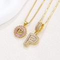 Golden pendant necklace set with pink crystal letter P and sparkling cubic zirconia stones - Gold P