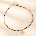 Collier en perles colorées avec un pendentif lettre U doré rond et chaîne ajustable - Lettre U