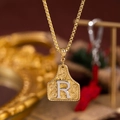 Collana dorata con ciondolo a piastrina quadrata, texture a rilievo e lettera R argento - Oro R