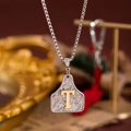Collier avec pendentif bouclier argenté, lettre T dorée et motifs floraux en relief - Lettre T