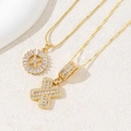 Golden iced-out cross pendant necklace with sparkling cubic zirconia on box chain - Letter X