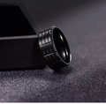 Dettaglio ravvicinato di un anello nero da uomo con fascia larga e trama a griglia industriale - US 6 / Nero