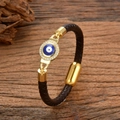 Braided brown leather evil eye bracelet with gold zircon charm on wood background - Style-3 (Blue & White Eye)