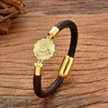 Pulsera trenzada de cuero marrón con colgante de serpiente dorada sobre madera vieja - Estilo Moneda de Serpiente Marrón Oscuro