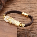 Détail du bracelet en cuir tressé religieux avec icône de saint doré et zircons blancs - Style Saint Jude Debout
