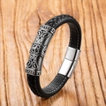 Close-up of black leather men's bracelet with vintage engraved metal plate and white stitching - Vintage Pattern Style