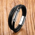 Nahaufnahme eines schwarzen Lederarmbands mit magnetischem Edelstahlverschluss auf Holz - Geflochtener Zylinder-Dekor-Stil (Stil 7)