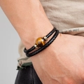 Macro detail of men's double-layer braided leather bracelet with tiger eye stone bead - Gold-Dark Tiger Eye