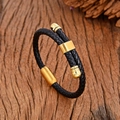 Geflochtenes schwarzes Lederarmband mit goldenem Magnetverschluss auf dunklem Holz - Gold Stil B