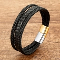 Close-up of woven black leather bracelet with two-tone magnetic metal clasp on wood - Black Braided Cord With Gold Silver Clasp