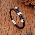 Geflochtenes Lederarmband mit Magnetverschluss aus Edelstahl auf rustikalem Holz - Silber Stil B