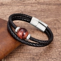 Detail showing the red-brown tiger eye stone and silver magnetic clasp on a braided leather band - Silver-Brown Stone
