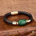 Detail of a braided leather bracelet with a green gemstone and a gold magnetic clasp - Dark Green Stone / Gold