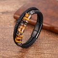 Close-up of triple tiger eye stones on black braided leather bracelet with magnetic clasp - Yellow Tiger Eye