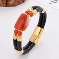 Dettaglio di un bracciale in pelle intrecciata con perla di agata rossa e chiusura dorata - Stile Agata Rossa (Stile-3)
