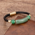 Detail eines schwarzen Lederarmbands mit grünen Steinen und goldenem Magnetverschluss - Gold-Aventurin