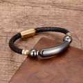 Geflochtenes schwarzes Lederarmband mit goldenem Magnetverschluss auf Holzhintergrund - Gold-Hämatit