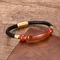 Detail of black braided leather bracelet with orange stone inlay and gold magnetic clasp - Gold-Red Agate