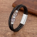 Détail d'un bracelet double en cuir tressé noir avec perles violettes et fermoir magnétique - Style Perle Violette Argentée