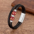 Gros plan d'un bracelet en cuir tressé double couche avec perles rouges et fermoir acier - Style Perle Mantra Rouge Argentée