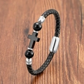 Détail d'un bracelet en cuir tressé noir avec pendentif croix et fermoir magnétique argenté - Style Croix et Perle Noir Poli