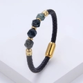 Nahaufnahme von schwarzem Lederarmband mit grauen Steinperlen und goldenem Metallverschluss - Dunkelgrau Grüne Facettierte Steinperlen
