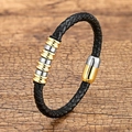Geflochtenes Lederarmband mit gold-silbernen Stahlringen auf rustikalem Holzgrund - Weißgold