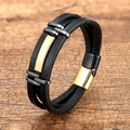 Detail van meerlaagse zwarte leren armband met gouden accenten en magnetische sluiting - Zwart Goud & Zwart Leer