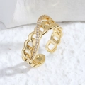 Detailaufnahme von goldfarbenem Ring mit Kettenstruktur und Zirkonia auf Stein-Hintergrund - Einstellbar Offen / Gold