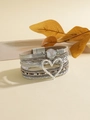 Dettaglio bracciale bohémien multistrato con ciondolo a cuore e chiusura magnetica - Argento
