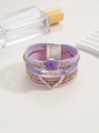 Detalle de pulsera boho multicapa con correas de cuero púrpura y cierre de corazón - Púrpura