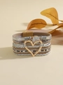 Dettaglio del bracciale bohémien multistrato in pelle con chiusura a cuore dorata - Stile Cuore Oro Argento