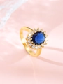 Macro shot of an oval blue sapphire ring with sparkling white zircon halo in gold plating - US 7 / Royal Blue (Gold)