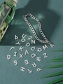Close-up van de zilveren roestvrijstalen schakelarmband en zesentwintig alfabetische hangers - Letter A