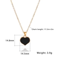 Macro shot of gold heart pendant with black enamel inlay and detailed beaded edging - Black