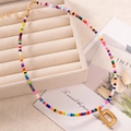 Collana artigianale di perline colorate con ciondolo a lettera D in metallo dorato - Lettera D