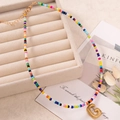 Collana artigianale di perline colorate con un ciondolo a lettera G in oro opaco - Lettera G