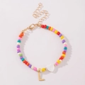 Kleurrijke kralenarmband met hartvormige kraal en gouden letter L bedeltje op wit - Letter L Stijl (B2504240890)
