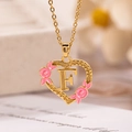 Collana a cuore dorata con fiori in smalto rosa e ciondolo con lettera F intagliata - Lettera F / Oro