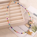 Collana bohémien fatta a mano con perline colorate e un ciondolo a lettera K dorata - Lettera K
