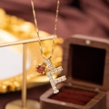Close-up of gold apple pendant with red crystals and diamond-studded F letter charm - Letter F