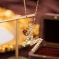 Vintage gold M letter pendant necklace with sparkling white zircons and red gem detail - Letter M