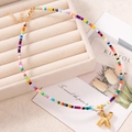 Collana artigianale di perline colorate con un ciondolo lucido a lettera X dorata - Lettera X