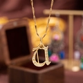 Elegant gold-plated copper necklace featuring a sparkling zircon-set cursive letter d - Letter U
