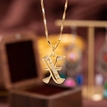 Golden pendant necklace with letter X design featuring sparkling cubic zirconia stones - Letter X