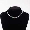 Rainbow macaron beaded necklace with a golden heart pendant featuring engraved letter E - Letter E