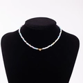 Rainbow bead necklace with golden heart pendant and letter F on a velvet stand - Letter F