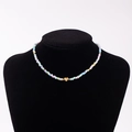 Rainbow seed bead necklace featuring a gold heart charm with letter Q on a black bust - Letter Q